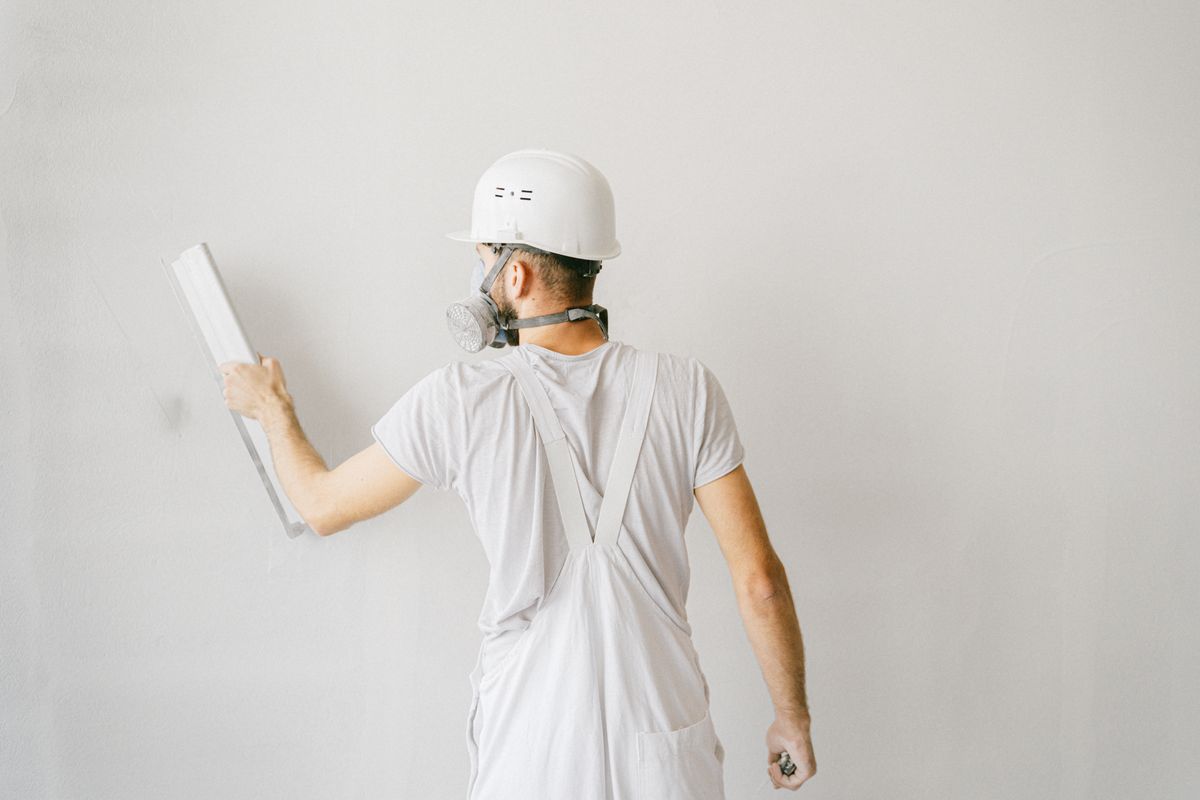 Beispielbild: Handwerker bearbeitet eine Innenwand